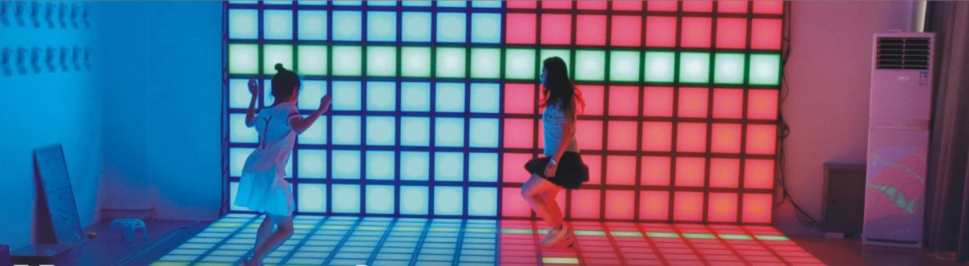 Interactive LED floor lit in blocks of colour across a large room